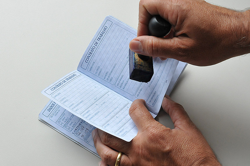 Foto de uma carteira de trabalho sendo carimbada